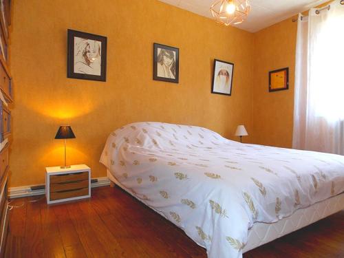 ein Schlafzimmer mit einem großen weißen Bett und Bildern an der Wand in der Unterkunft Louberne in Casteljaloux