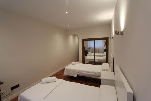 サラマンカにあるHotel Castellano Centroの小さな部屋で、ベッド2台、鏡が備わります。