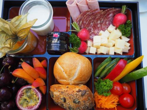 a lunch box filled with cheese and vegetables and meats at relexa hotel München in Munich