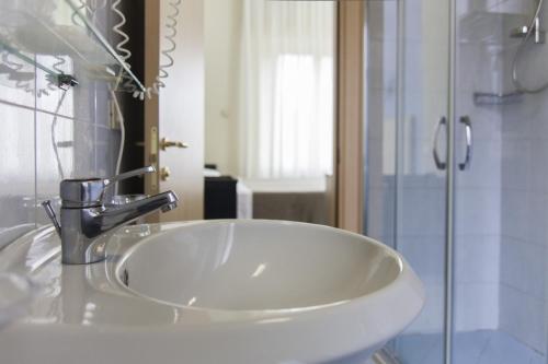 a white sink in a bathroom with a shower at Hotel Brasile in Montecatini Terme