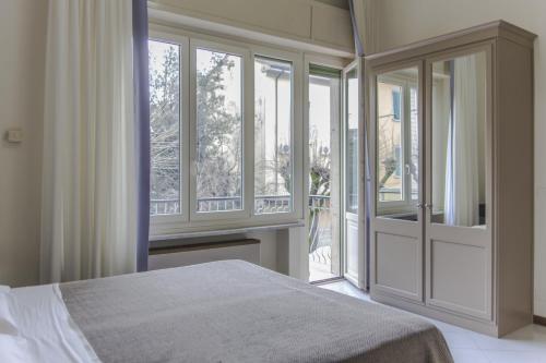 a bedroom with a bed and large windows at Hotel Brasile in Montecatini Terme