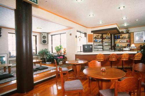 a restaurant with tables and chairs in a room at Pals Inn Raicho in Hakuba