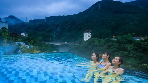 three women are sitting in a swimming pool at Kinugawa Hotel Mikazuki in Nikko