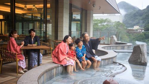 a family sitting in the water in a fountain at Kinugawa Hotel Mikazuki in Nikko