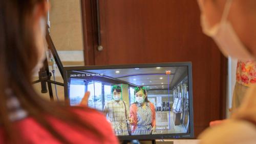 a woman standing in front of a television with a picture of two people wearing masks at Kinugawa Hotel Mikazuki in Nikko