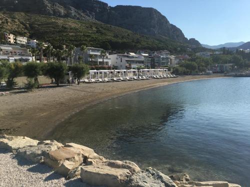 a beach with chairs and buildings and the water at Apartment Duce in Omiš