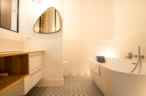 y baño con bañera blanca y espejo. en Magnifique appartement avec 3 chambres en Hypercentre, en Burdeos