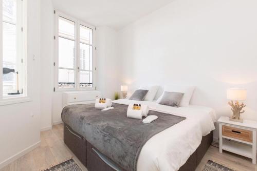 une chambre blanche avec un grand lit et une fenêtre dans l'établissement Astoux YourHostHelper, à Cannes