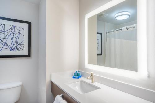een witte badkamer met een wastafel en een spiegel bij Holiday Inn Express Hotel & Suites Frankfort, an IHG Hotel in Frankfort