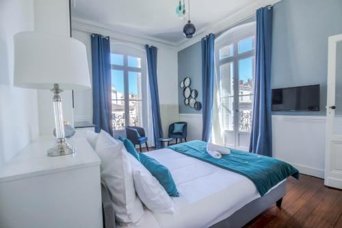 a bedroom with a bed with blue walls and windows at Magnifique appartement avec 3 chambres en Hypercentre in Bordeaux