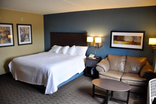 Habitación de hotel con cama y sofá en AmericInn by Wyndham Clear Lake, en Clear Lake