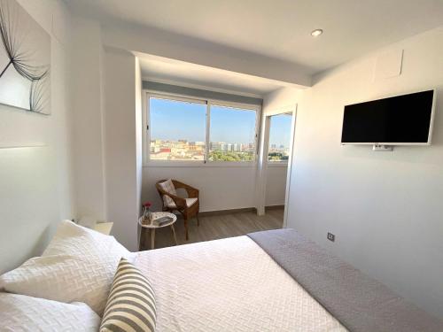 Schlafzimmer mit einem Bett und einem Flachbild-TV in der Unterkunft Residencial Santa Justa - Vacacional Sevilla in Sevilla