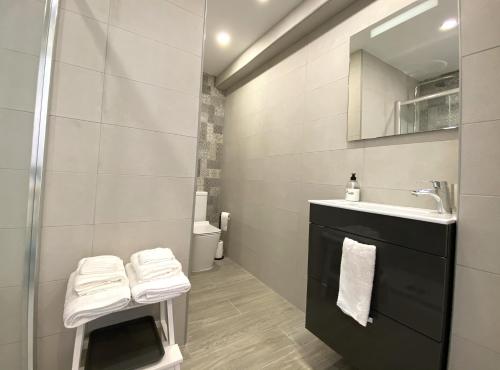ein Bad mit einem Waschbecken und einem Spiegel in der Unterkunft Residencial Santa Justa - Vacacional Sevilla in Sevilla