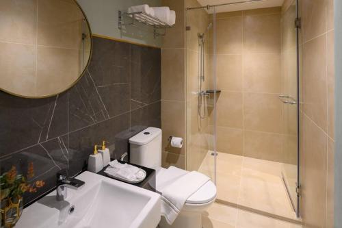een badkamer met een douche, een toilet en een wastafel bij The Mulberry Bangkok Khaosan Road in Bangkok