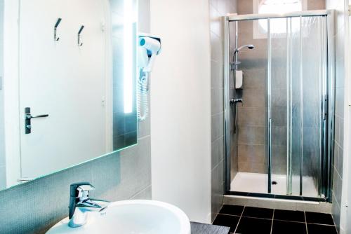 a bathroom with a sink and a shower at Hôtel Stella in Lourdes