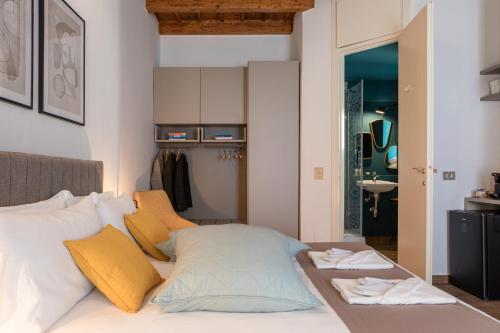 1 dormitorio con 1 cama con almohadas amarillas y blancas en BePlace Apartments in Magenta en Milán