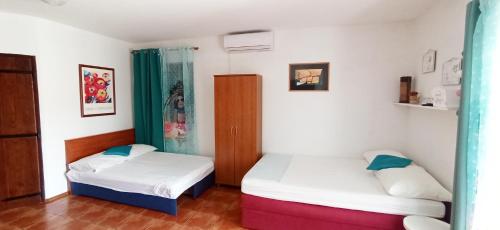Habitación con 2 camas en una habitación en Apartments Edita, en Rogoznica