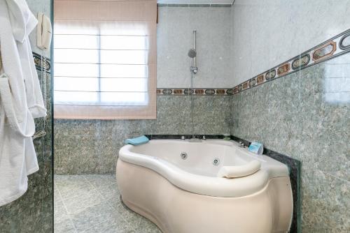 a bath tub in a bathroom with a window at Hotel Canadá in Tarragona