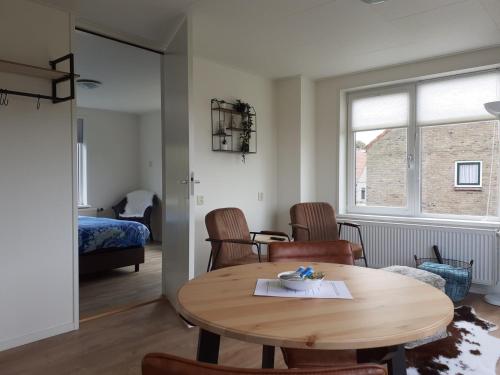 a room with a table and chairs and a bedroom at de Pastorie in Hollum