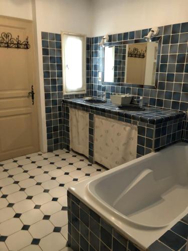 a bathroom with a tub and a sink and a mirror at Villa dans le LUBERON à 2 km de LOURMARIN in Lauris