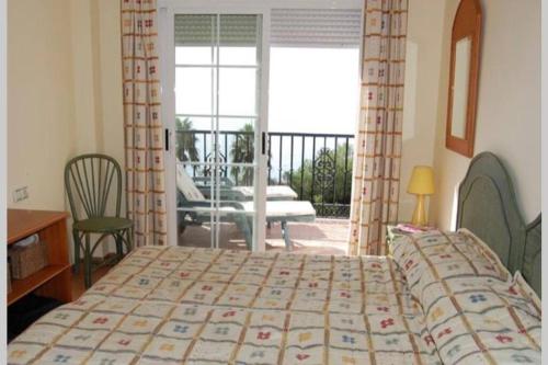 Schlafzimmer mit einem Bett und Blick auf einen Balkon in der Unterkunft Apartamento con vistas al mar in Nerja