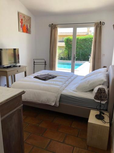 ein Schlafzimmer mit einem großen Bett und einem Fenster in der Unterkunft Villa dans le LUBERON à 2 km de LOURMARIN in Lauris