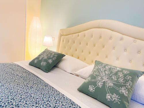 una camera da letto con un letto con cuscini verdi e bianchi di Trastevere Boulevard a Roma