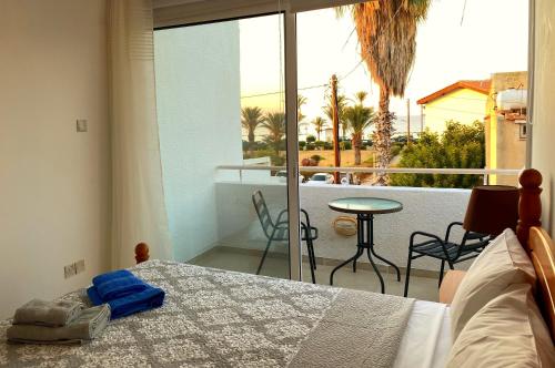 sypialnia z łóżkiem oraz balkon ze stołem w obiekcie JustSmile - Seaview Maisonette in Latchi w mieście Latsi