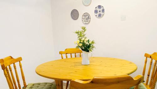 a wooden table with a vase of flowers on it at JustSmile - Seaview Maisonette in Latchi in Polis Chrysochous