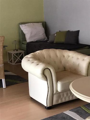 a living room with a white couch and a bed at Ferienwohnung auf der Blue Ranch in Engen