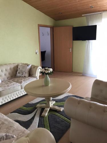 a living room with a couch and a table and chairs at Ferienwohnung auf der Blue Ranch in Engen