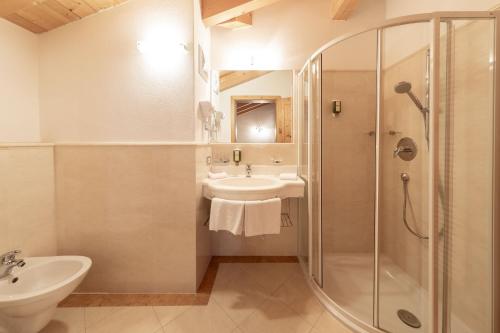 a bathroom with a sink and a shower and a toilet at Almhotel Glieshof in Malles Venosta