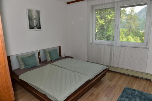 uma cama num quarto com uma janela em Ferienwohnung Isabell em Ebensee