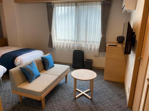 a hotel room with a bed and a couch and a window at Rinn Niomon in Kyoto