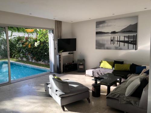 a living room with a couch and a swimming pool at Villa moderne avec piscine, front de mer in Casablanca