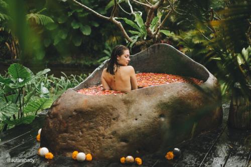 a woman sitting in a large rock bathtub at Hideout Falcon in Selat
