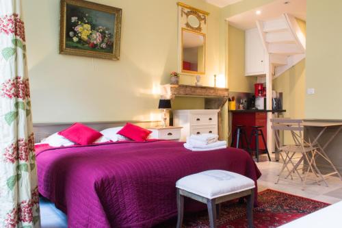 a bedroom with a bed with a purple bedspread at Appartement - Petit Buffon in Dijon