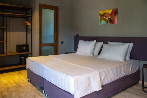 a bedroom with a large bed with white sheets and pillows at Magnetic Resort Ureki in Ureki