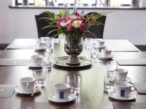 a table with a vase of flowers on a table at Verve Hotel in Bedford