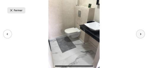 a bathroom with a toilet and a sink at Villa moderne avec piscine, front de mer in Casablanca