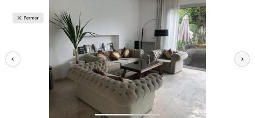 a living room with two couches and a table at Villa moderne avec piscine, front de mer in Casablanca