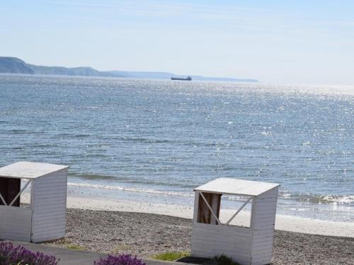 two white boxes sitting on a beach near the water at The View on the terrace in Weymouth