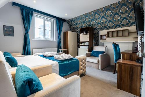 a bedroom with blue curtains and a bed and a couch at Vilenza Hotel in London