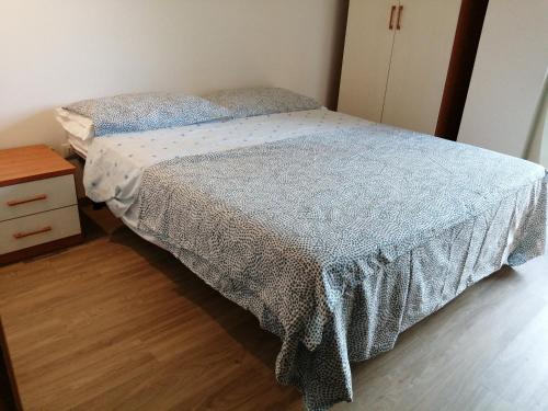 a bedroom with a bed with a blue comforter at Apartment Annive in Levico Terme