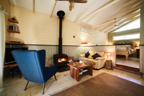 ein Wohnzimmer mit einem blauen Stuhl und einem Kamin in der Unterkunft Rustic Spirit in Bilpin