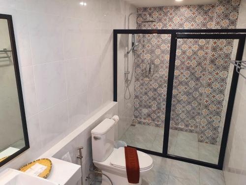 a bathroom with a shower and a toilet and a sink at USABAI Riverside Boutique Hotel in Chanthaburi