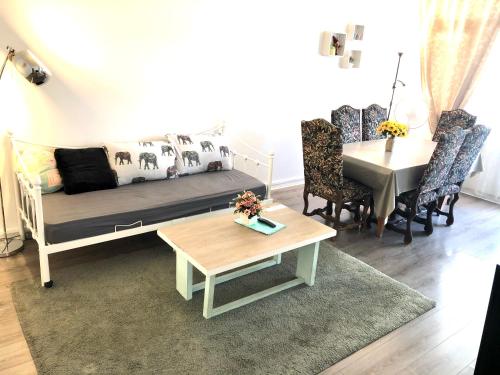 un soggiorno con divano e tavolo di Cosy 74m2 apartment close to Paris a Houilles