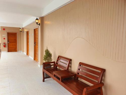 two wooden benches sitting in a hallway at USABAI Riverside Boutique Hotel in Chanthaburi