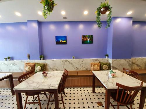 a restaurant with two tables and a purple wall at USABAI Riverside Boutique Hotel in Chanthaburi