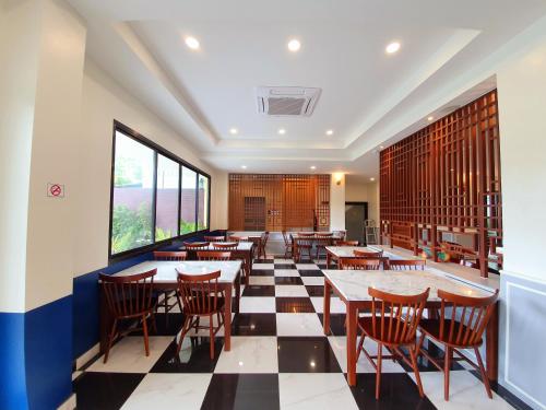 a restaurant with tables and chairs and a checkered floor at USABAI Riverside Boutique Hotel in Chanthaburi